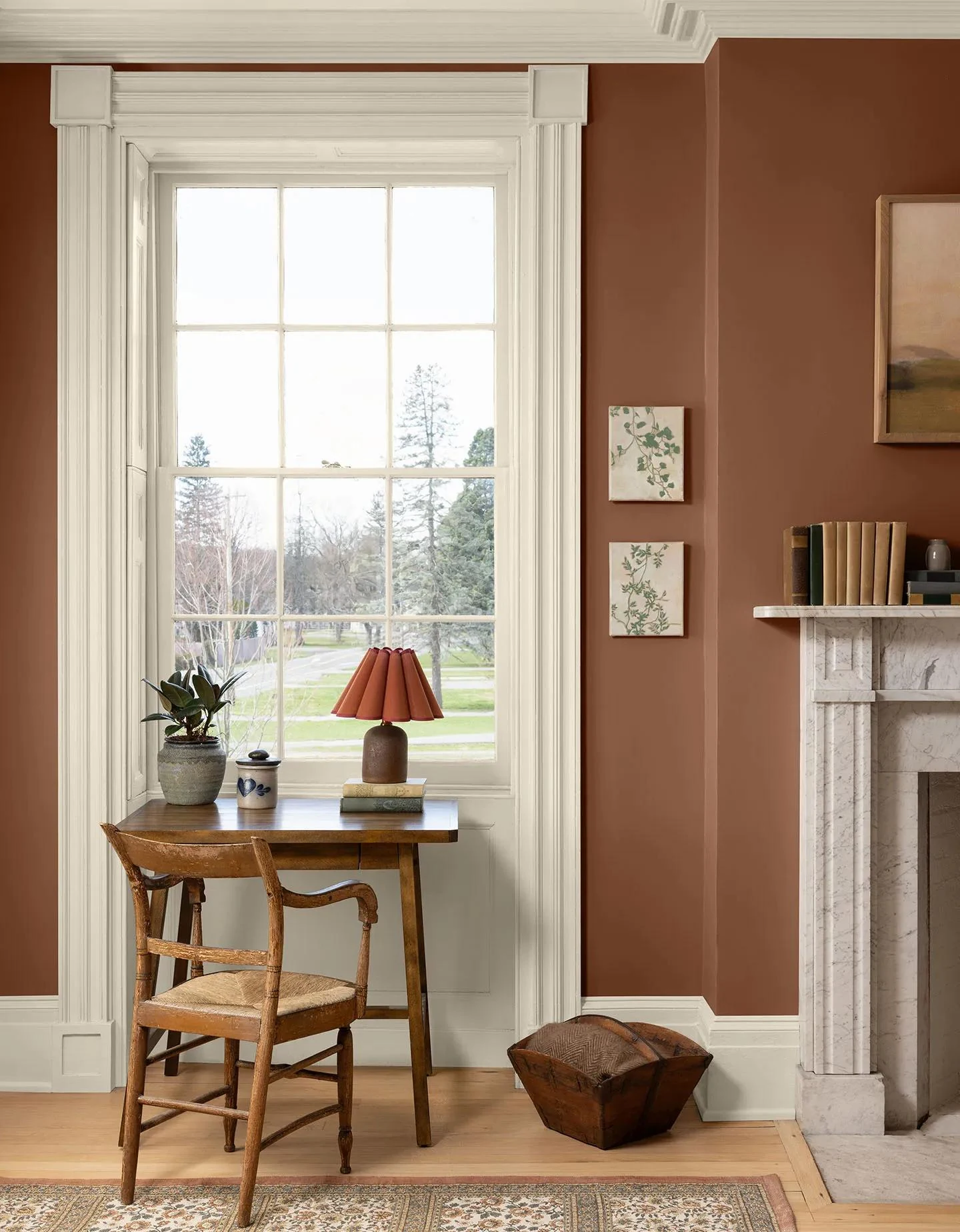 A living room with Antique Copper walls, White Down trim, a marble fireplace, and a patterned rug