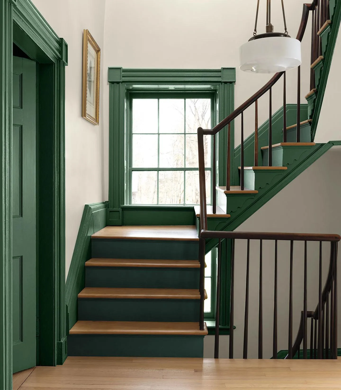An entryway with White Down walls and Webster Green doors, trim, and stair risers